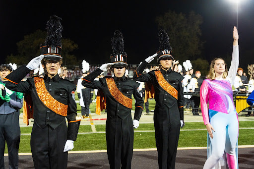 Drum majors junior Charlie Plante, senior Jack De Lone, senior Joseph Myers and guard captain senior Emma Odenwald salute at the awards presentation at the Sept. 14 competition in Franklin.
